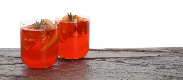 Photo of Aperol spritz cocktail, orange slices and rosemary in glasses on grey textured table against white background