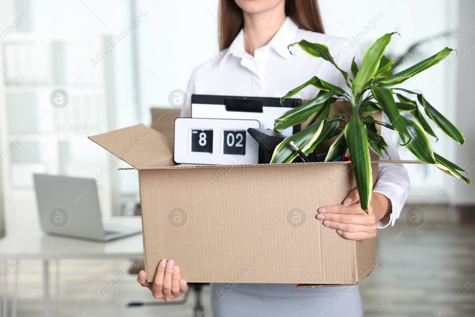 Photo of Young woman carrying box with stuff at office, closeup