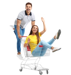 Young couple with shopping cart on white background