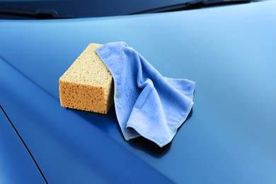 Sponge and rag on car hood. Cleaning products