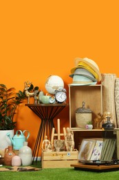 Many different items near orange wall in room. Garage sale