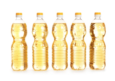 Row of plastic bottles with oil on white background