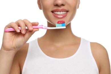 Woman holding toothbrush with paste on white background, closeup