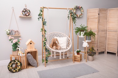 Easter photo zone with floral decor and swing chair indoors