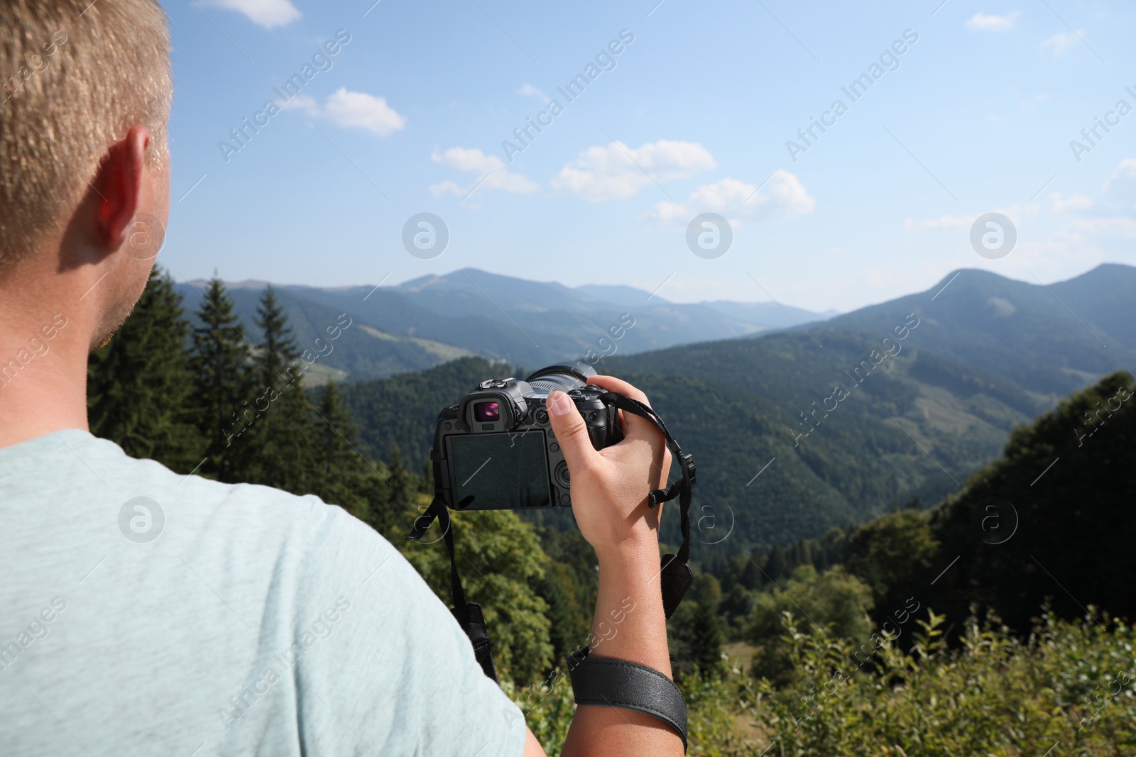 Photo of Professional photographer with modern camera in mountains, closeup