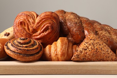 Photo of Different tasty freshly baked pastries on white table