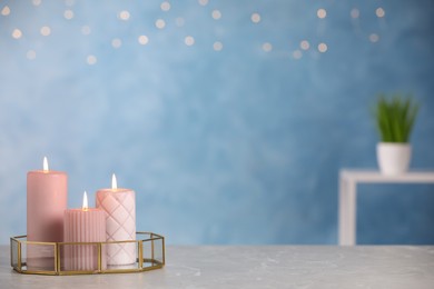 Photo of Burning candles on light grey marble table. space for text