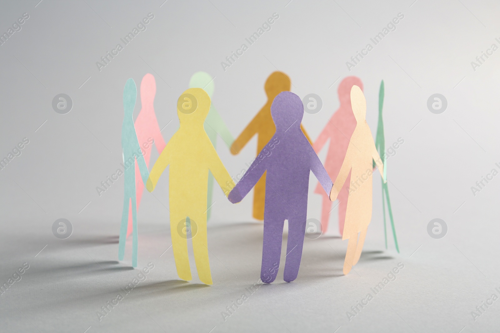 Photo of Paper human figures making circle on white background. Diversity and Inclusion concept