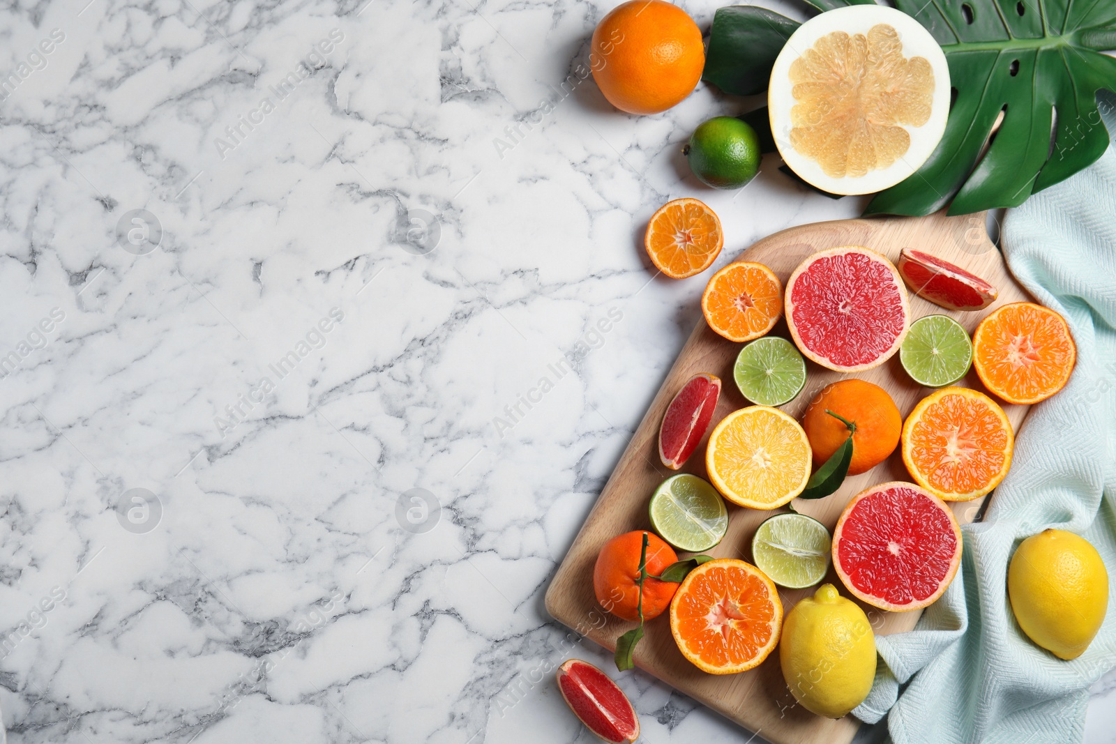 Photo of Different citrus fruits on marble background, top view. Space for text