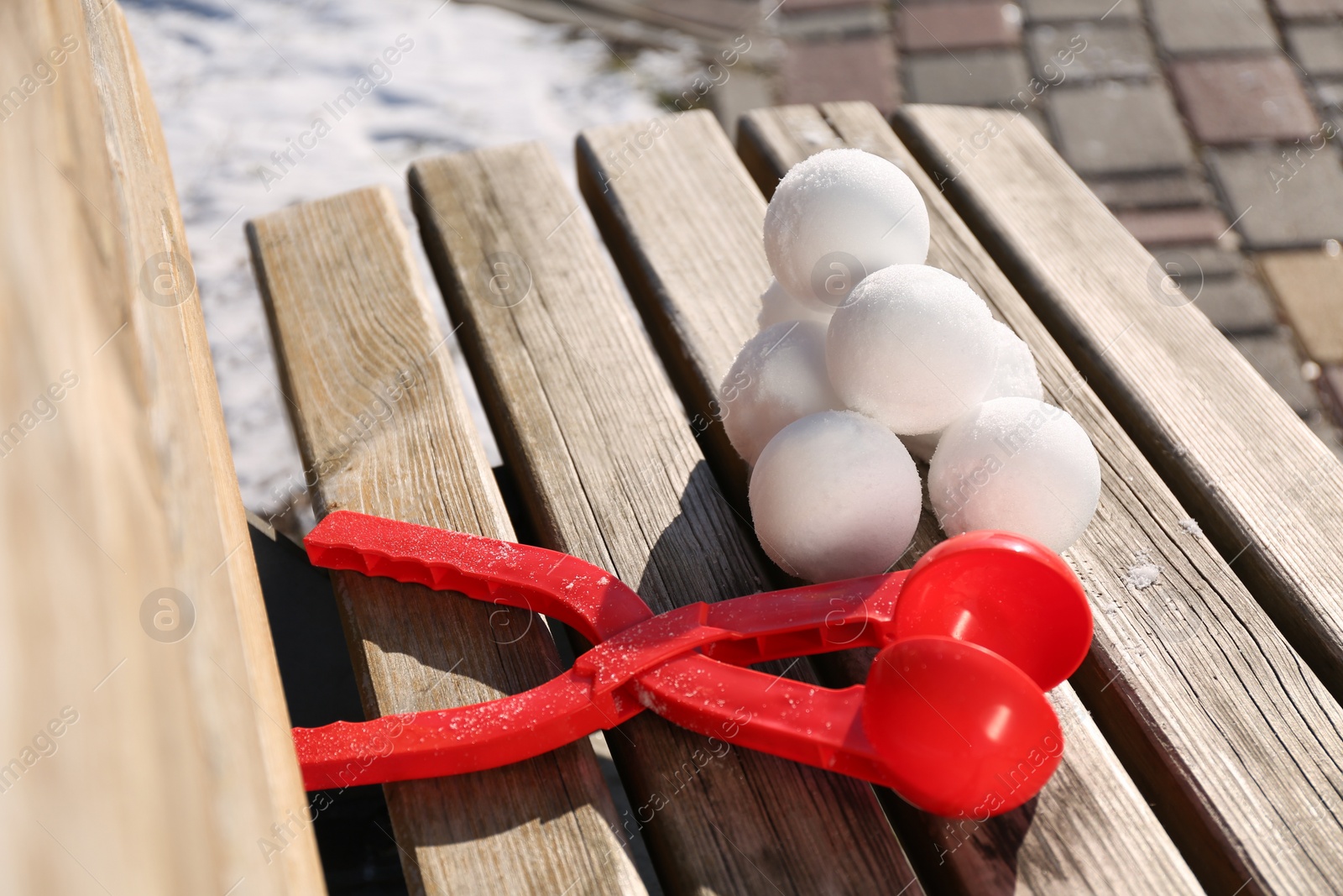 Photo of Snowballs and plastic tool on bench outdoors