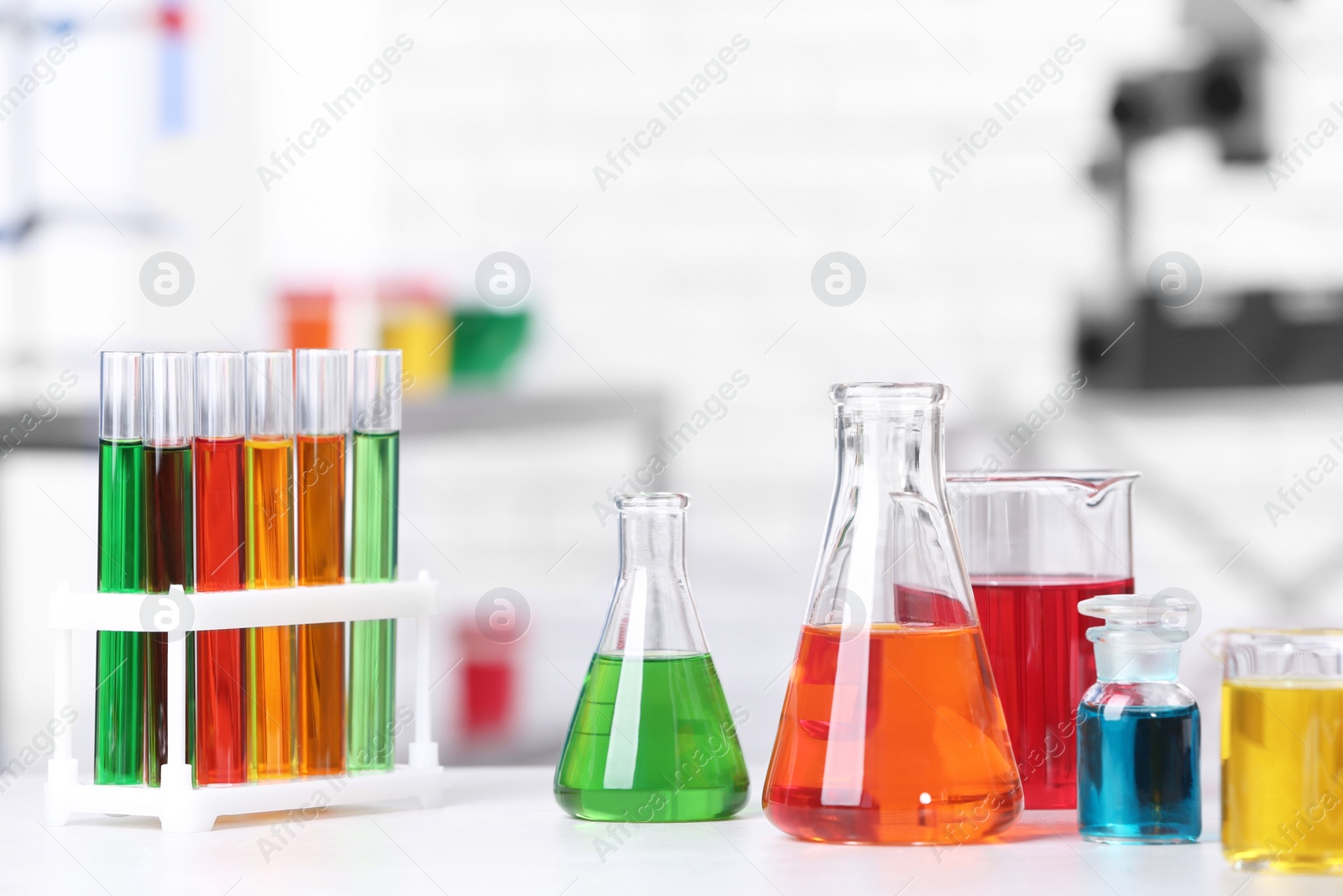 Photo of Different glassware with samples on table in chemistry laboratory