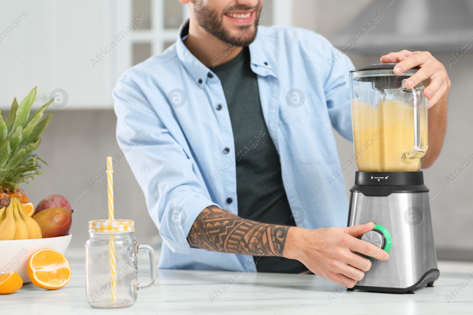 Photo of Man preparing ingredients for tasty smoothie at white marble table in kitchen, closeup