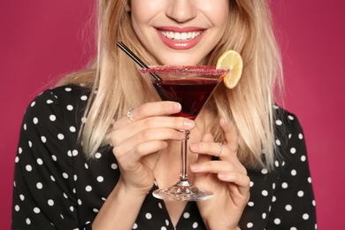 Photo of Beautiful young woman with glass of martini cocktail on color background, closeup