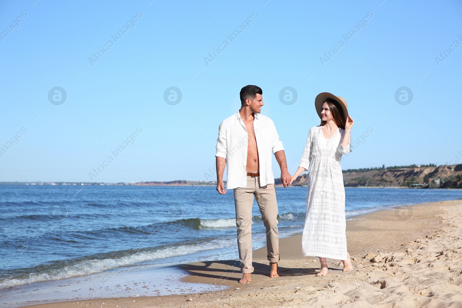 Photo of Lovely couple walking on beach. Space for text