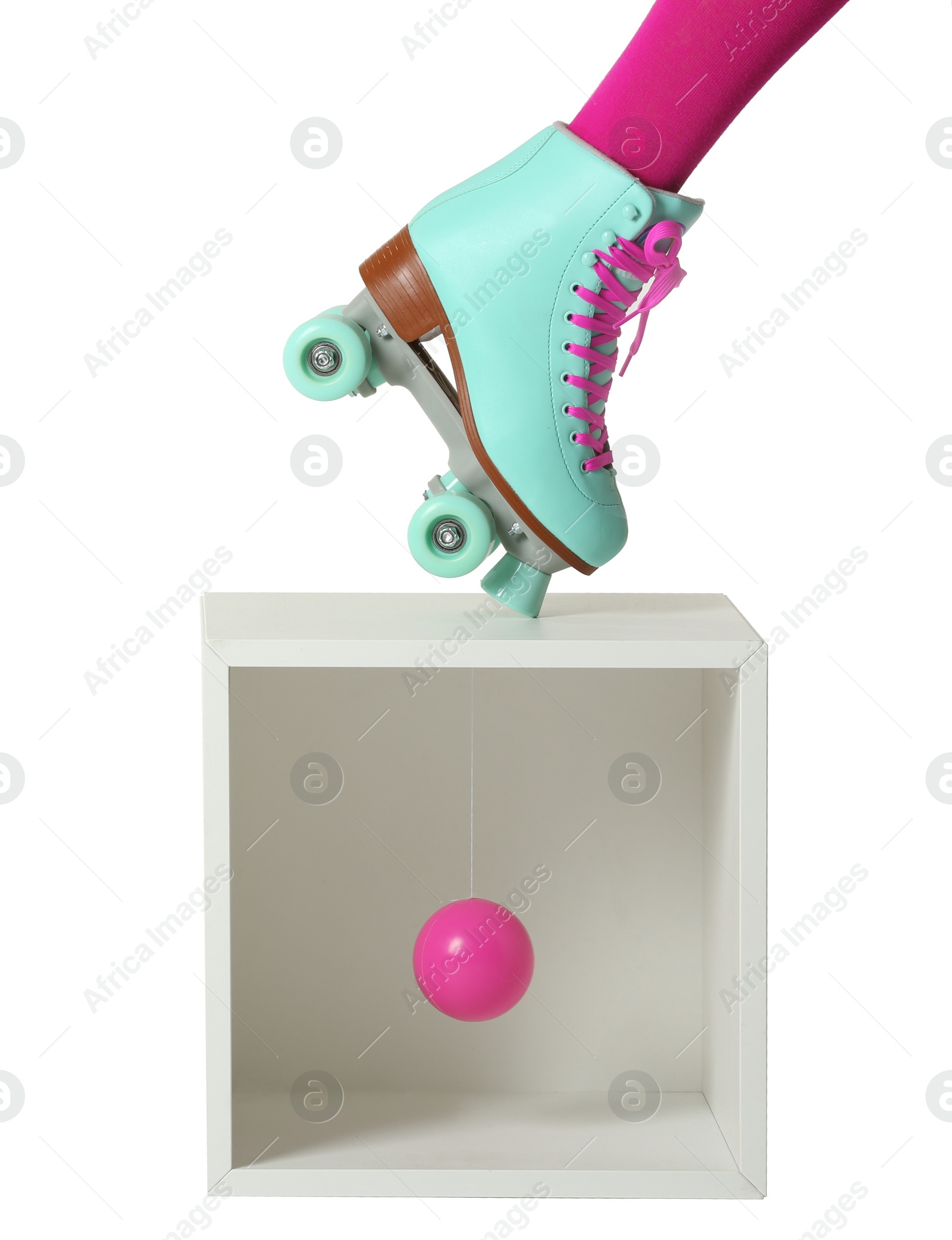 Photo of Woman wearing vintage roller skate and storage cube with ball on white background, closeup