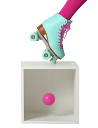 Photo of Woman wearing vintage roller skate and storage cube with ball on white background, closeup