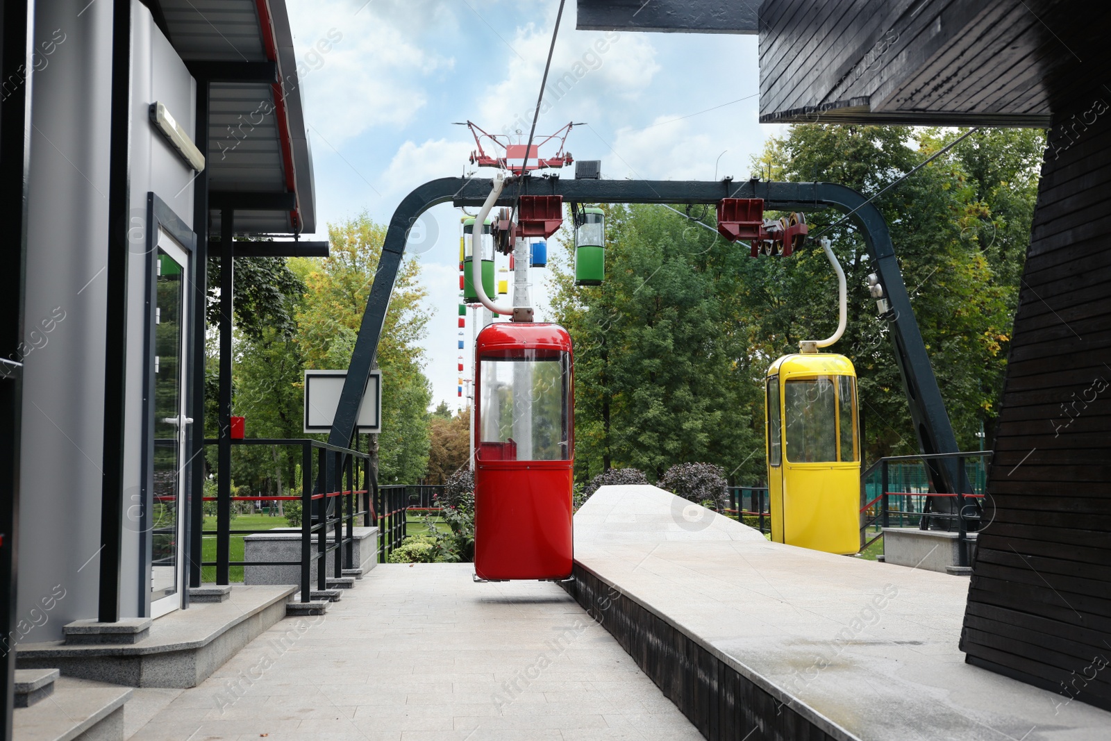 Photo of View of cableway with bright cabins in park on autumn day