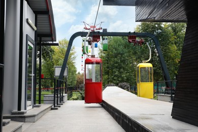 View of cableway with bright cabins in park on autumn day