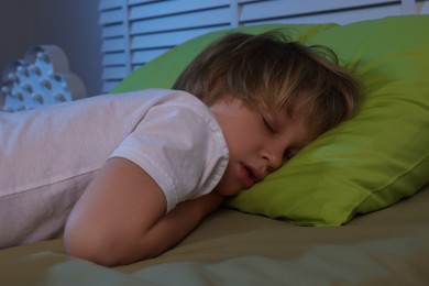 Little boy snoring while sleeping on bed at night