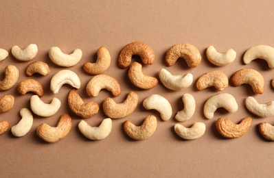 Photo of Tasty cashew nuts on color background, flat lay