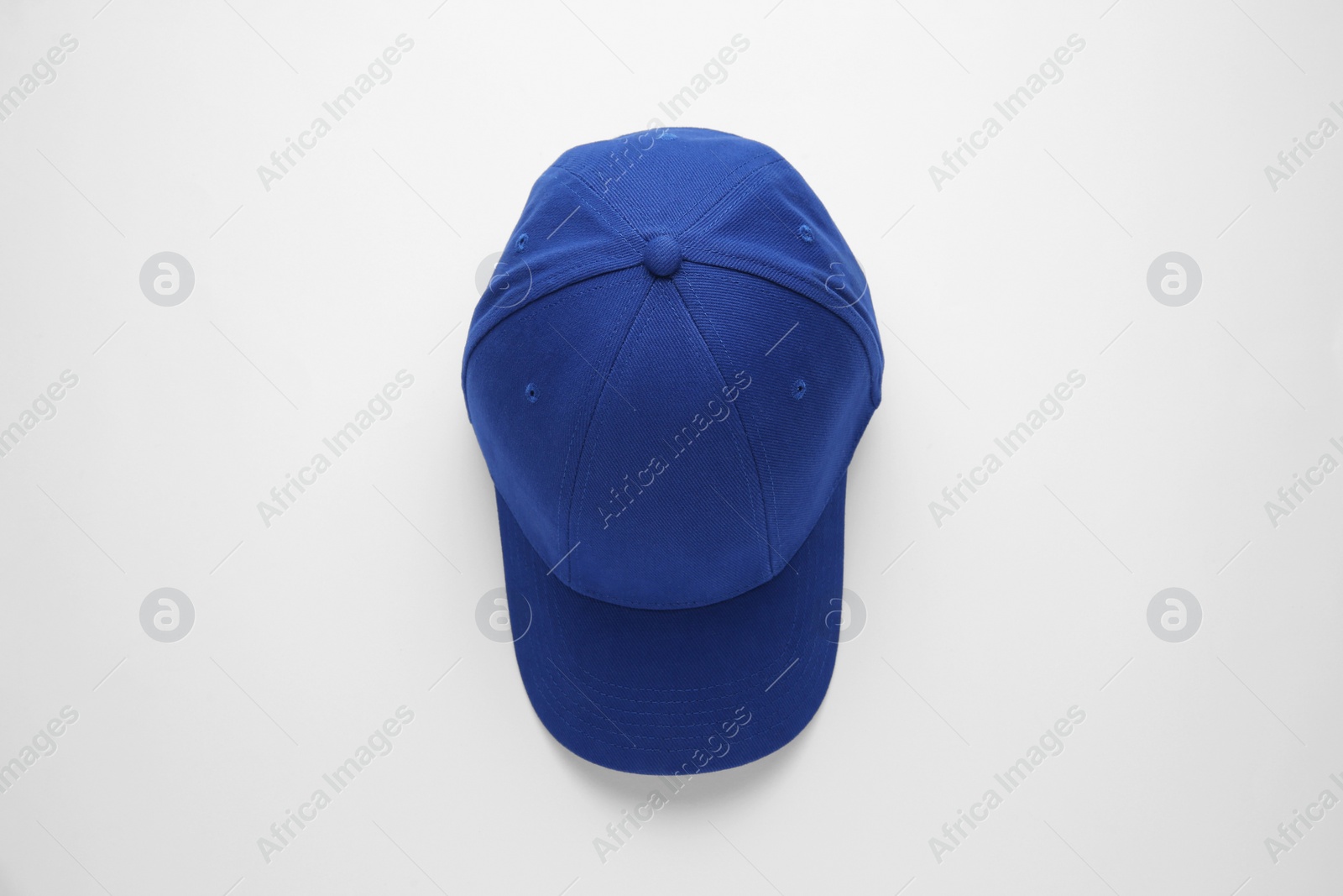 Photo of Stylish blue baseball cap on white background, top view