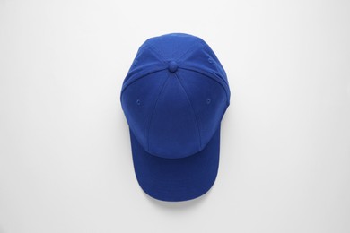 Photo of Stylish blue baseball cap on white background, top view