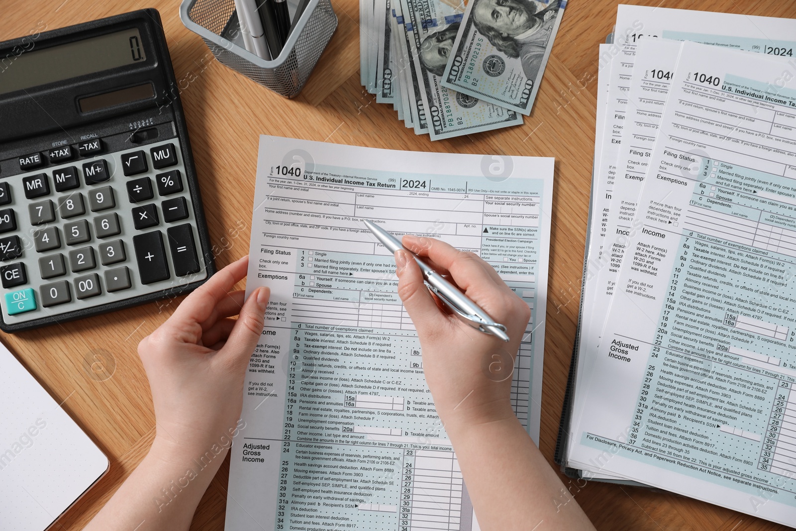 Photo of Payroll. Woman working with tax return forms at wooden table, top view