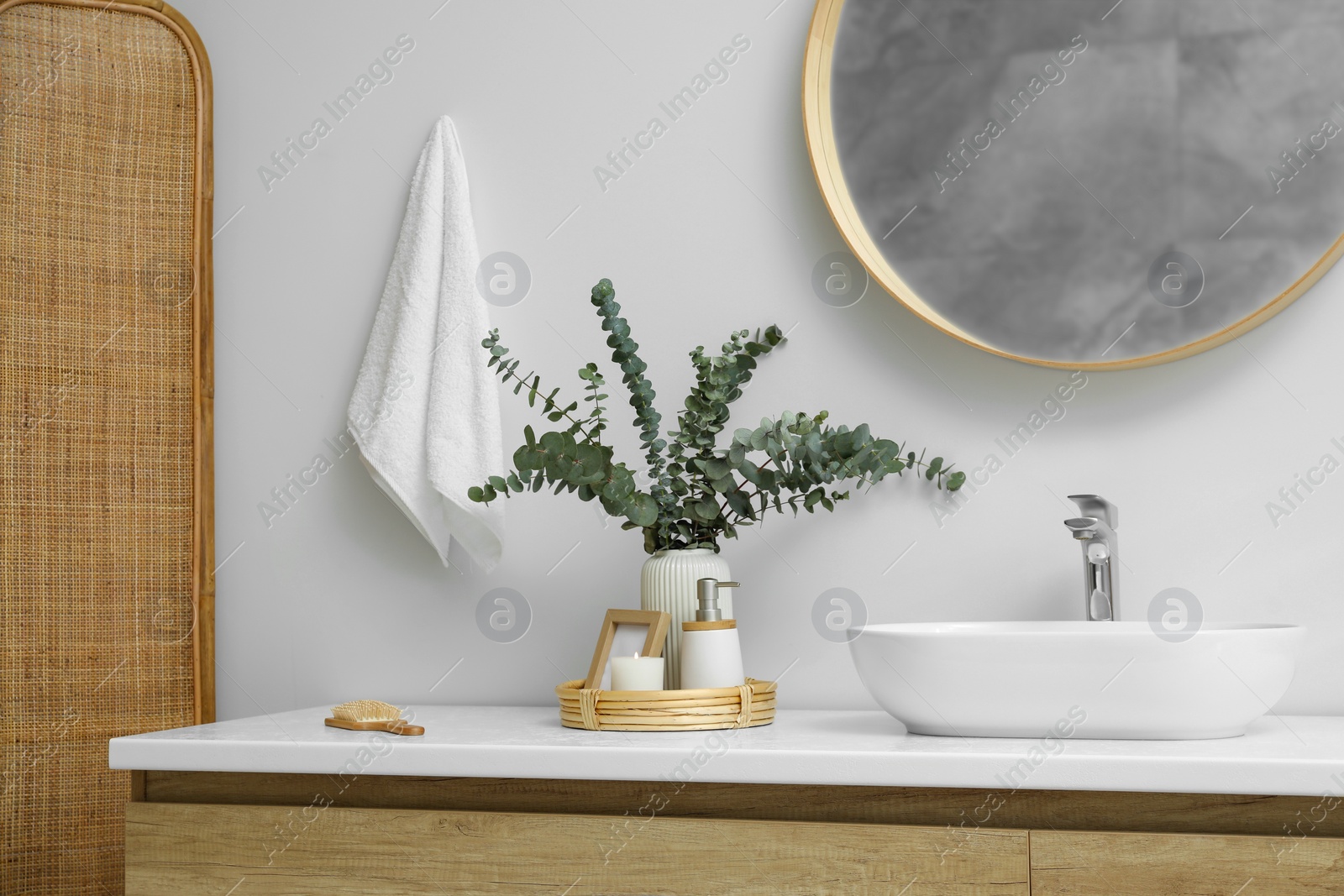 Photo of Stylish mirror, eucalyptus branches and vessel sink in modern bathroom. Interior design