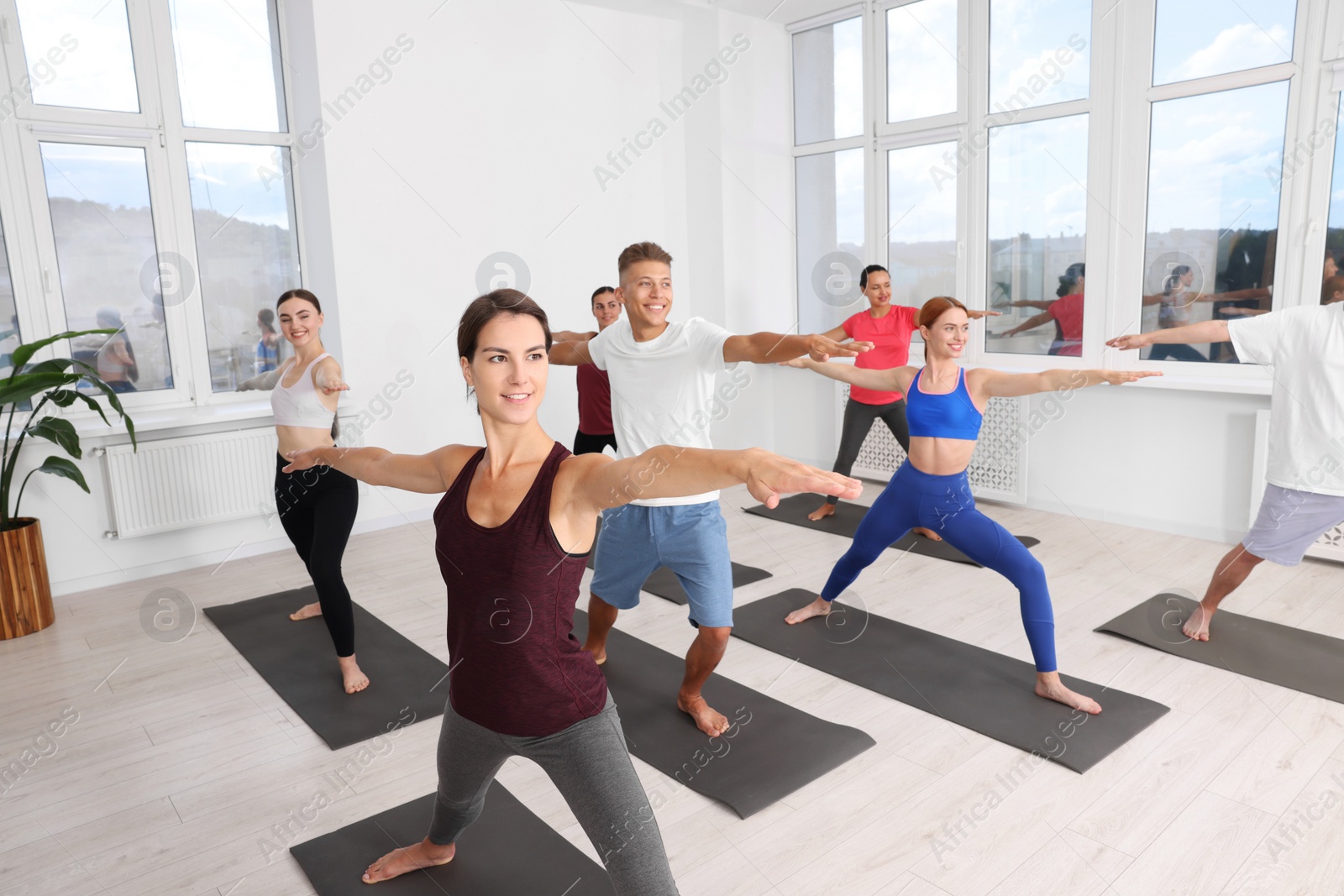 Photo of Group of people practicing yoga on mats indoors