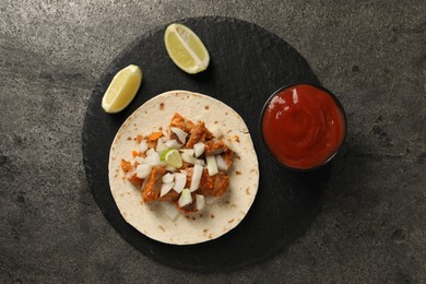 Photo of Delicious taco with vegetables, meat and ketchup on grey textured table, top view