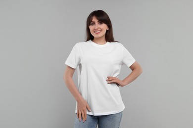 Smiling woman in white t-shirt on grey background