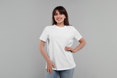 Photo of Smiling woman in white t-shirt on grey background