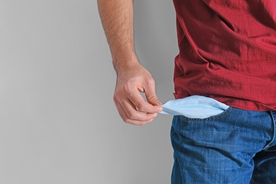 Photo of Man showing empty pocket on light background, closeup with space for text