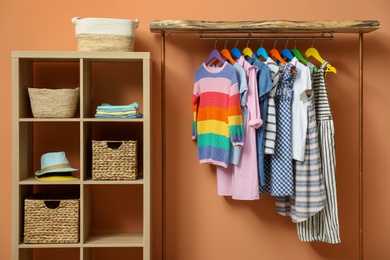 Photo of Different child's clothes hanging on rack in room