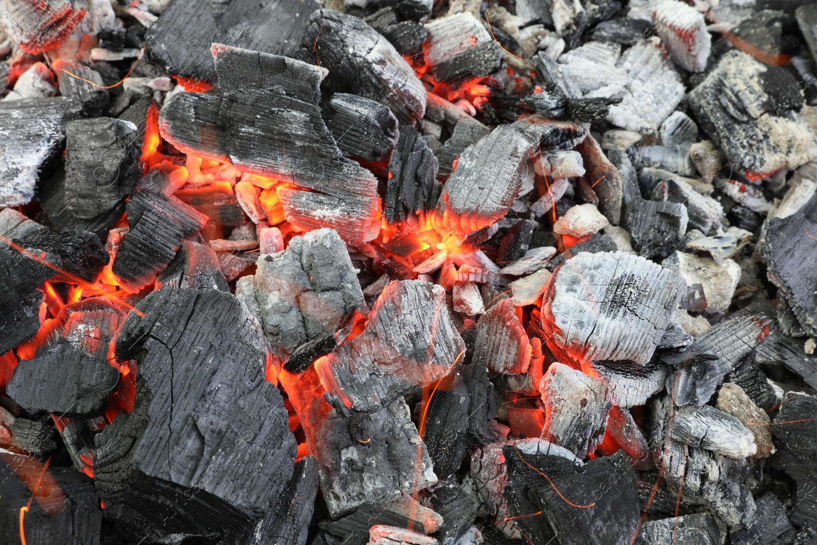 Photo of Many smoldering coals as background, top view