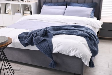 Photo of Soft blue plaid on bed in room