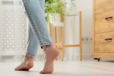 Photo of Woman stepping barefoot in room at home, closeup with space for text. Floor heating