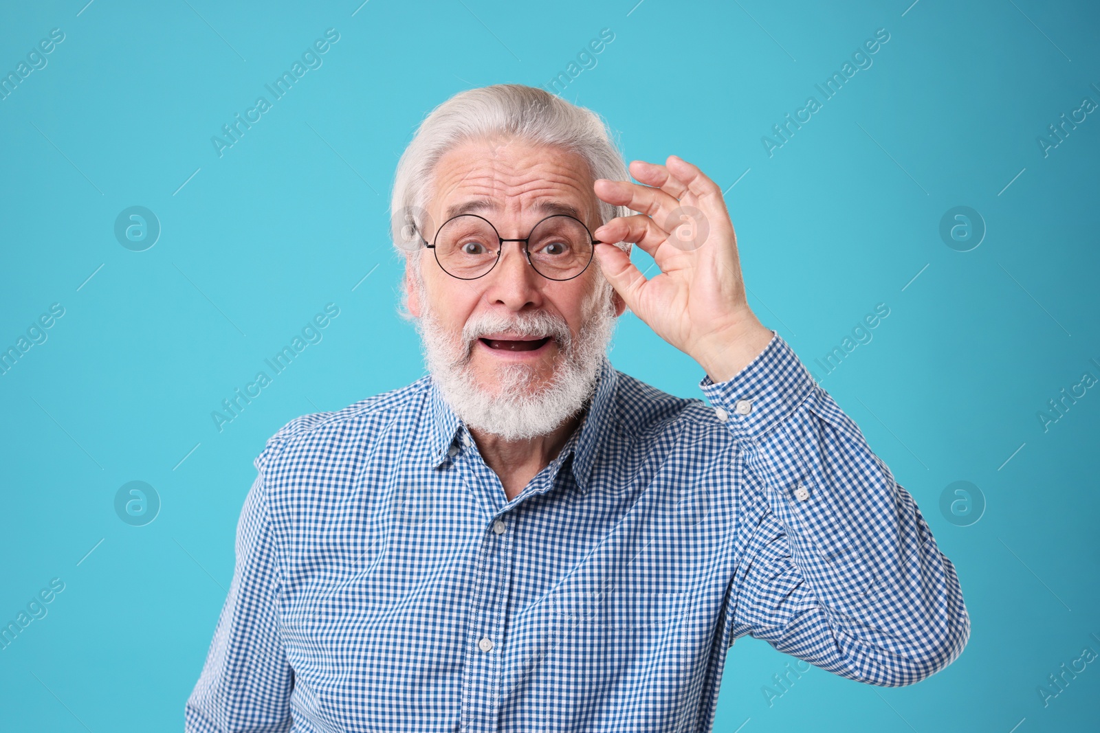 Photo of Portrait of stylish grandpa with glasses on light blue background