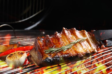 Image of Delicious ribs with rosemary and vegetables on barbecue grill