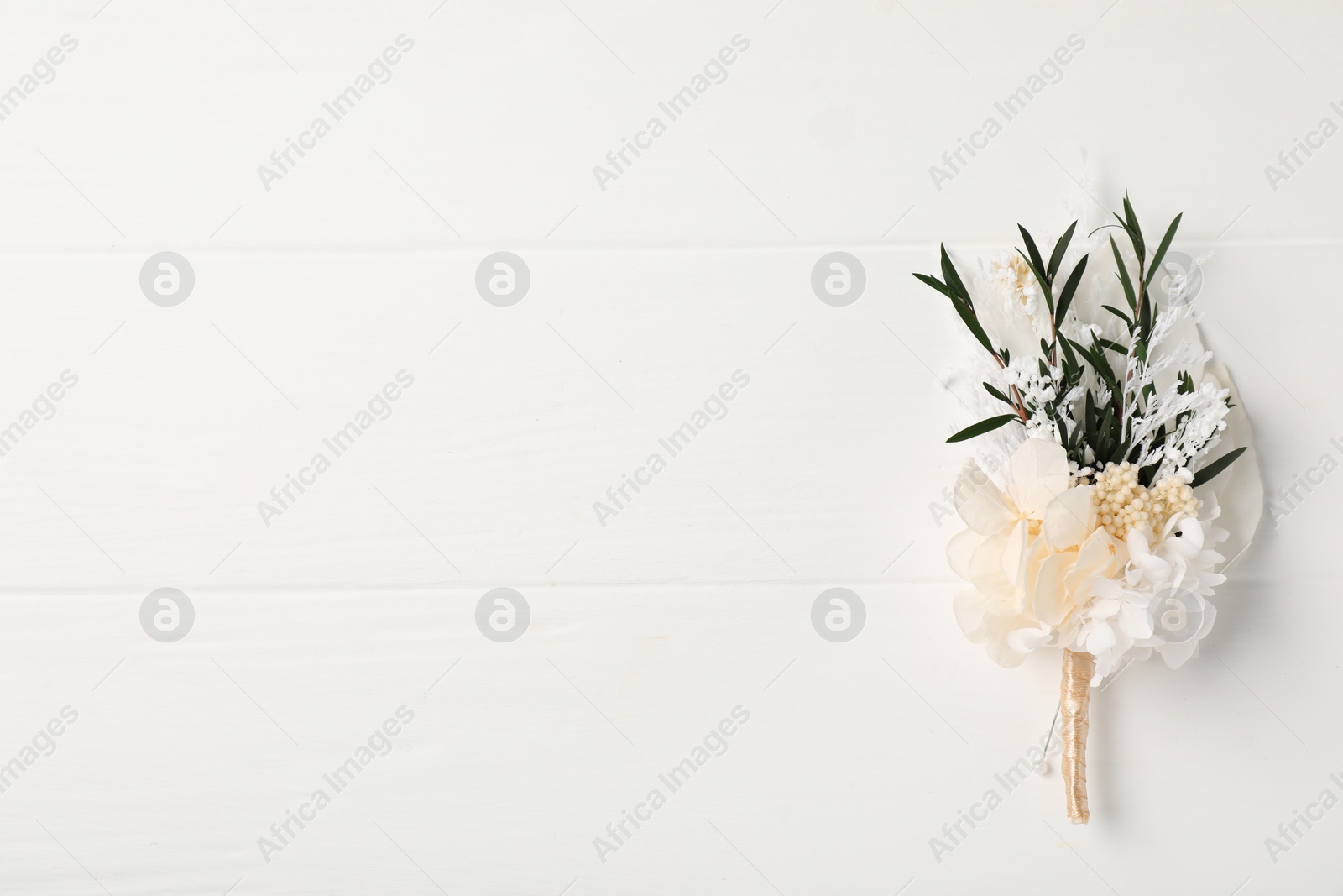 Photo of Beautiful boutonniere on white background, top view. Space for text