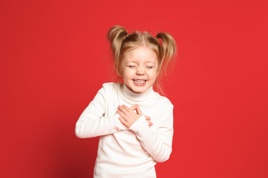 Photo of Portrait of cute little girl on red background