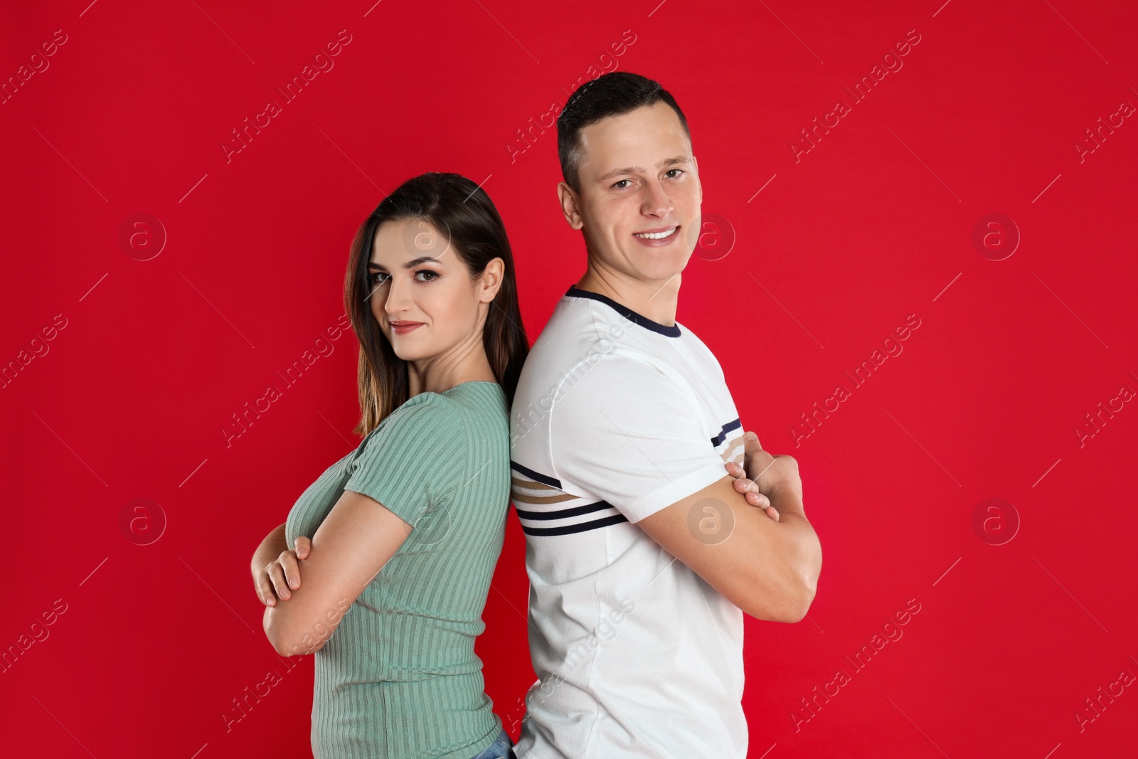 Photo of Happy young couple posing on red background