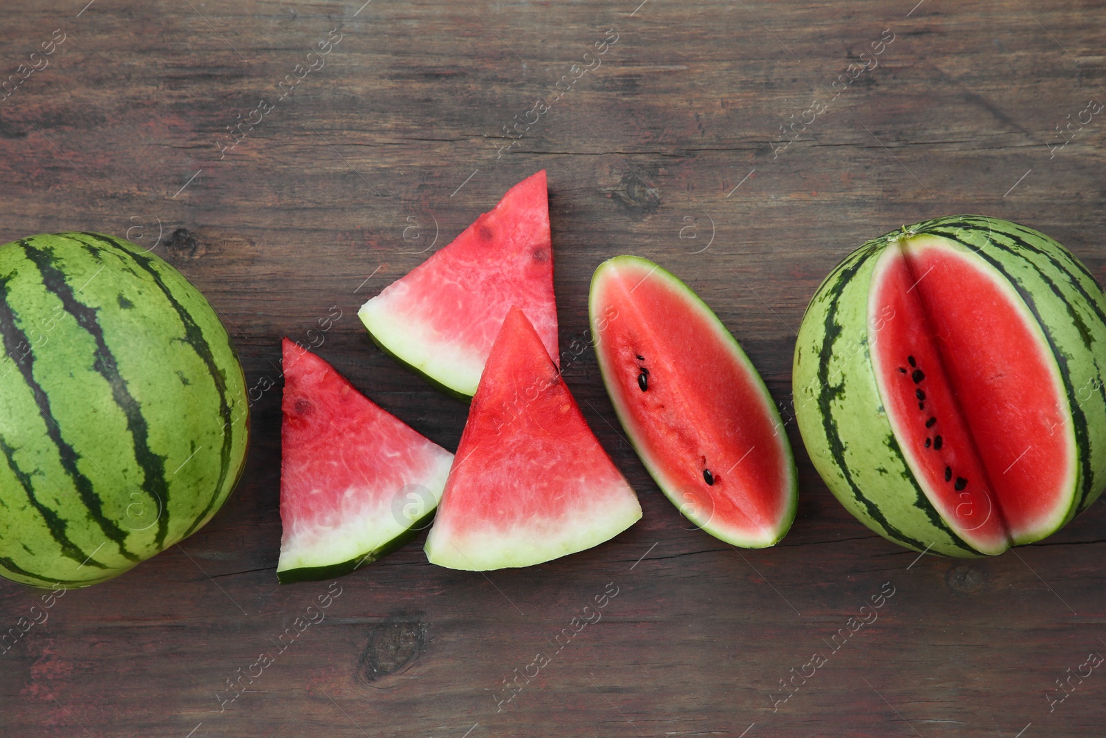 Photo of Delicious ripe watermelons on wooden table, flat lay