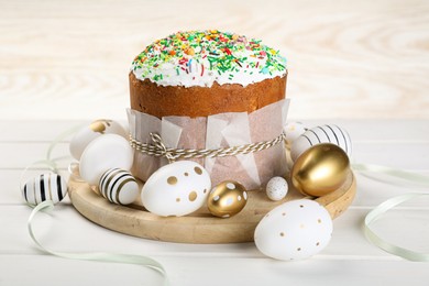 Traditional Easter cake with sprinkles and painted eggs on white wooden table