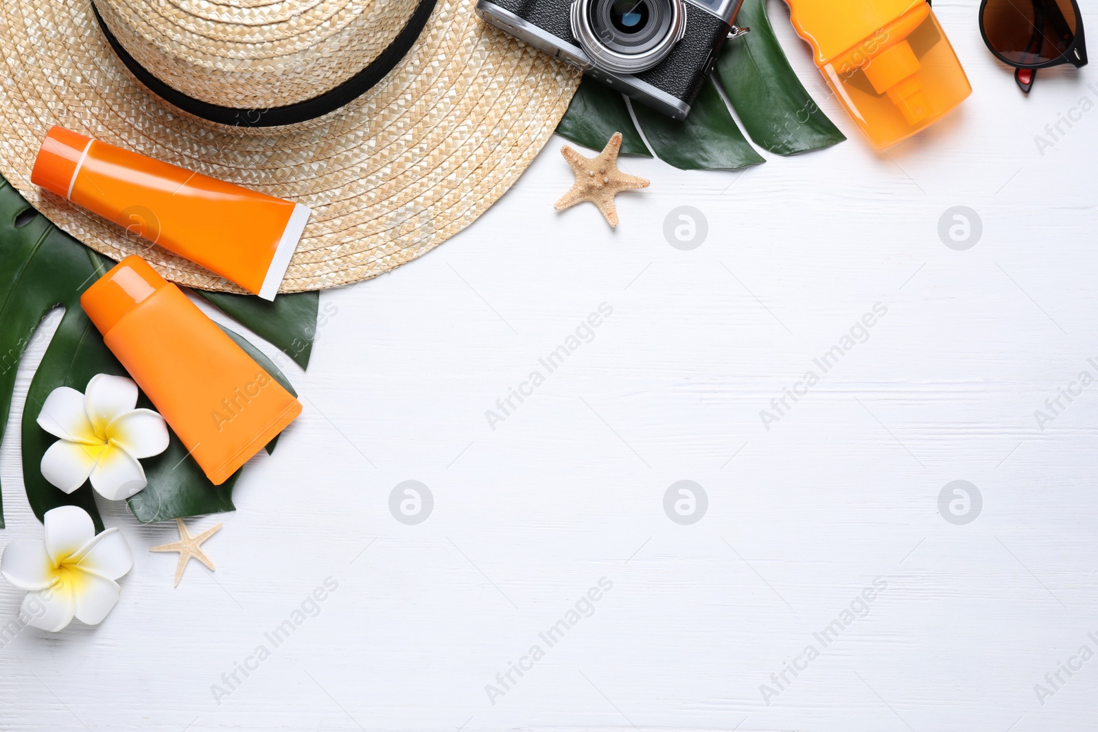 Photo of Sun protection products and beach accessories on white wooden background, flat lay. Space for text