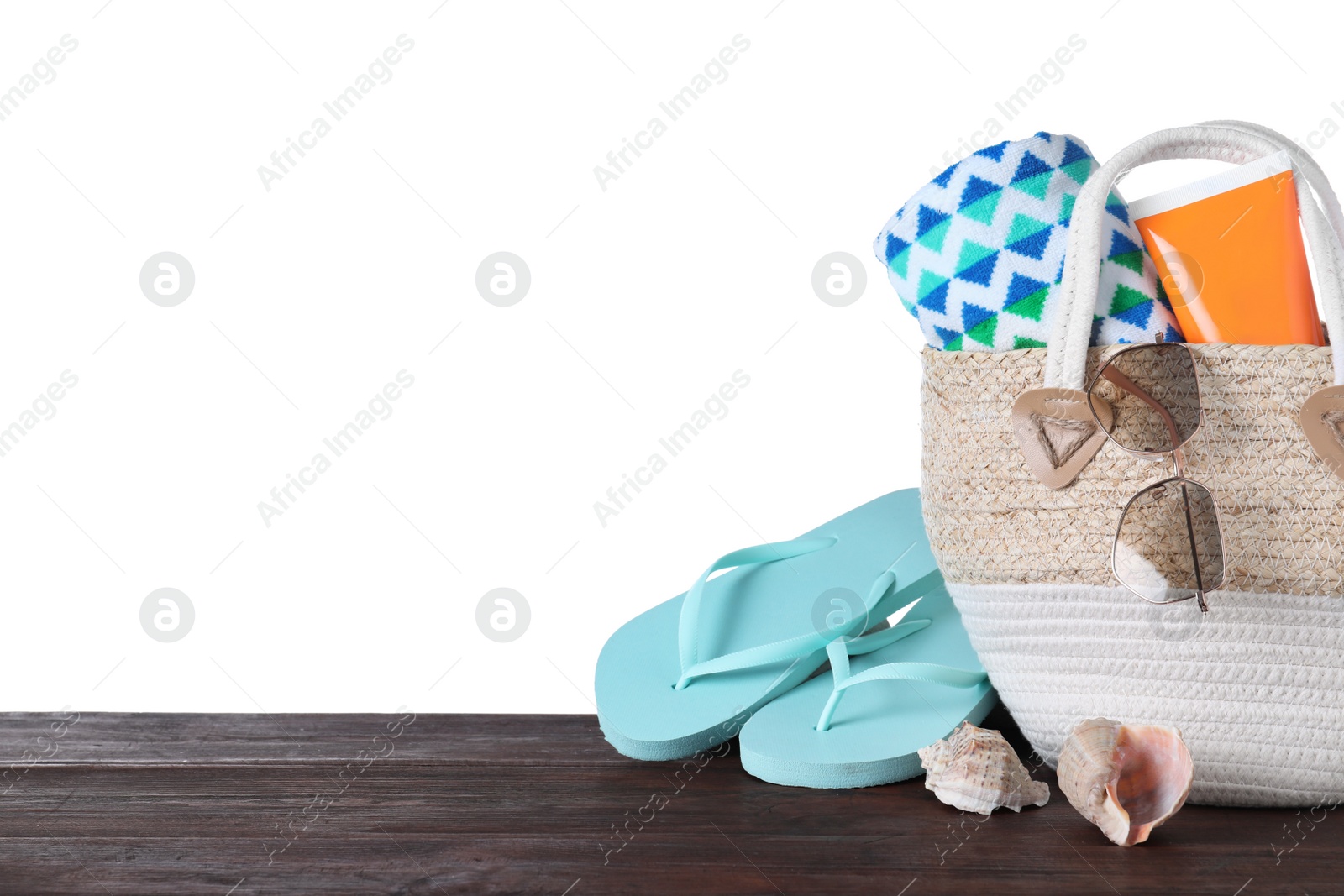 Photo of Different beach objects on wooden table against white background. Space for text