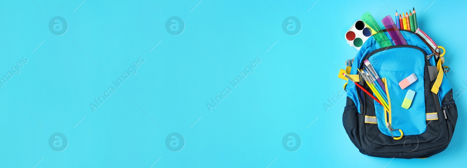 Image of Stylish backpack with different school stationery on light blue background, top view and space for text. Banner design