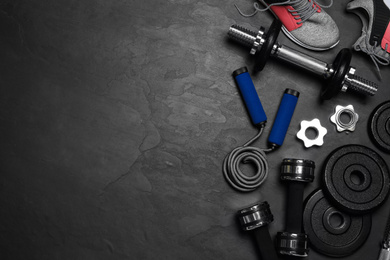 Photo of Gym equipment on black background, flat lay. Space for text