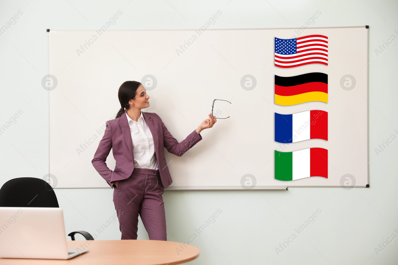 Image of Foreign languages teacher near whiteboard with different flags in modern classroom