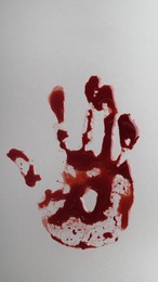 Photo of Bloody handprint on light grey background, top view